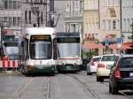 Auf der Maximilianstrasse in Augsburg geht es verkehrsreich eng zu. In der Haltestelle Moritzstrasse steht CityFlex Nr. 897 der Linie 2, ein Combino der Linie 64 steht dahinter und wartet auf die Einfahrmglichkeit und gegenber fhrt Combino 823 der Linie 13 gleich in die Haltestelle ein, am 30.07.2013. 