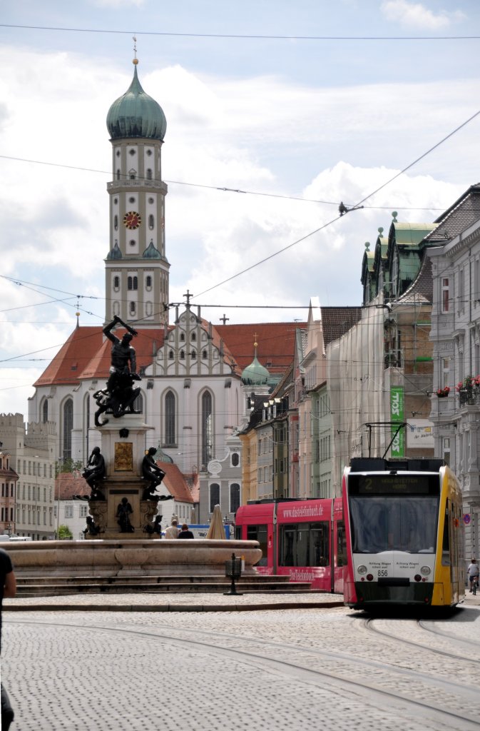 Combino 856 der Augsburger Strassenbahn hat im Jahr 2011 Telekom-Werbung, in der Maximilianstrasse schlngelt sich hier die Bahn um den Herkulesbrunnen und fhrt auf den Ulrichsplatz zu; Beide Werbeseiten sind gut erkennbar, am 25.08.2010.